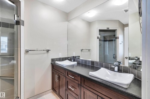 Bathroom featuring a dual vanity with rectangular vessel sinks, dark wood-finish cabinetry, and a full-width mirror - 9 Shorewood Crescent, Leduc, AB - Indoor Photo Showing Bathroom