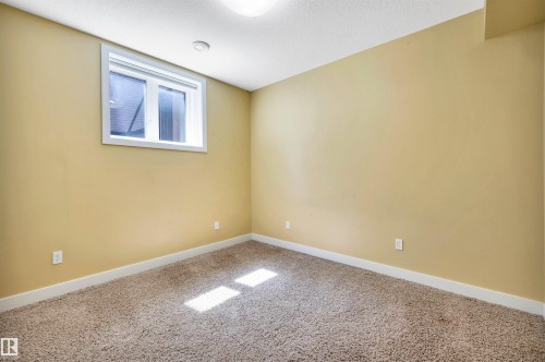 Neutral-toned room featuring a single window with white trim, light beige wall paint, plush carpet flooring, and white baseboards - 9 Shorewood Crescent, Leduc, AB - Indoor Photo Showing Other Room