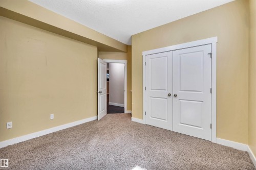 Room featuring neutral carpeting, light beige walls, white trim, and white paneled doors - 9 Shorewood Crescent, Leduc, AB - Indoor Photo Showing Other Room