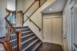 Grand entryway featuring a multi-level staircase with dark wood handrails and metal balusters - 