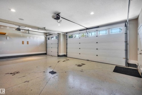 Spacious garage featuring two overhead doors with transom windows - 9 Shorewood Crescent, Leduc, AB - Indoor Photo Showing Garage