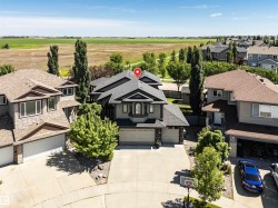 Two-story residence featuring a gray exterior, dark shingle roof, and a prominent bay window - 