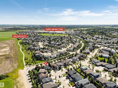 Aerial perspective of a residential community featuring extensive green spaces, a marked walking path, and mature trees - 9 Shorewood Crescent, Leduc, AB - Outdoor With View