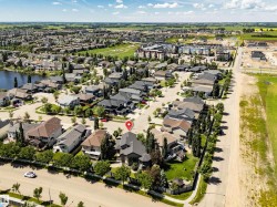 Aerial overview of an established residential area featuring a central property with dark gray roofing - 