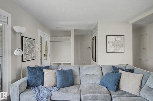 Bright interior space featuring light wall tones, recessed lighting, a front entry door with an oval glass insert, and a built-in coat rack with shelving - 5407 106 Avenue Nw, Edmonton, AB - Indoor Photo Showing Living Room