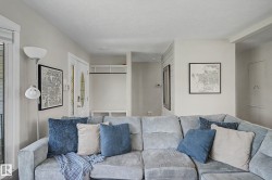 Bright interior space featuring light wall tones, recessed lighting, a front entry door with an oval glass insert, and a built-in coat rack with shelving - 