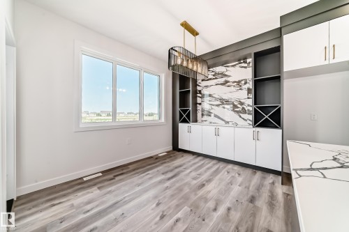 Integrated custom built-ins featuring open shelving and wine storage, complemented by a large three-pane window - 14 Tenuto Link, Spruce Grove, AB - Indoor