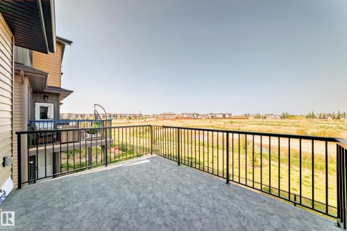 Expansive upper-level deck featuring a textured concrete surface and black metal railings - 14 Tenuto Link, Spruce Grove, AB - Outdoor With Exterior
