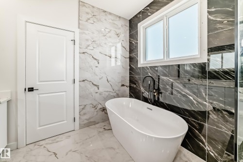 Contemporary bathroom featuring a freestanding soaking tub with a floor-mounted matte black faucet - 14 Tenuto Link, Spruce Grove, AB - Indoor Photo Showing Bathroom