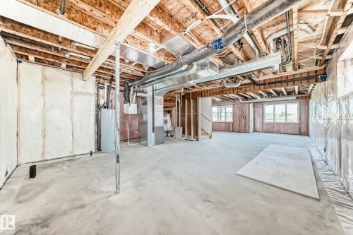 Unfinished basement featuring exposed wood joists, concrete flooring, visible HVAC ductwork, and multiple windows - 14 Tenuto Link, Spruce Grove, AB - Indoor Photo Showing Basement