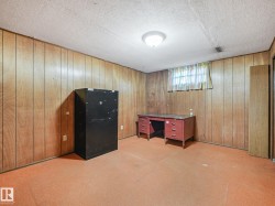 Room featuring wood paneling on walls, carpeted flooring, and a flush-mount ceiling light fixture - 