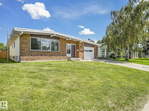 Ranch-style residence featuring a brick facade, integrated single-car garage, and a spacious front lawn - 15011 72A Street, Edmonton, AB 