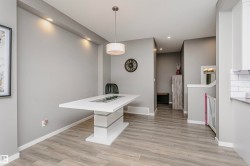 Dining area featuring a modern white pedestal table with a recessed centerpiece - 