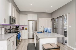 Contemporary kitchen featuring light wood-finish flooring and recessed lighting - 