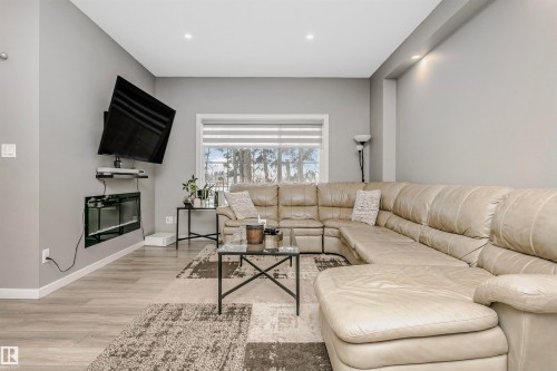 Living area featuring light gray walls, recessed lighting, and wood-finish flooring - 7322 Chivers Crescent, Edmonton, AB 