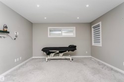Spacious room featuring light grey carpeting and neutral wall paint - 