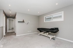 Spacious room featuring light gray walls, light gray carpet, recessed lighting, and a horizontal window - 
