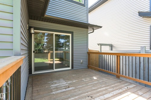 Outdoor wood-finish deck with a wood-finish railing and vertical balusters - 7322 Chivers Crescent, Edmonton, AB 