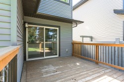 Outdoor wood-finish deck with a wood-finish railing and vertical balusters - 