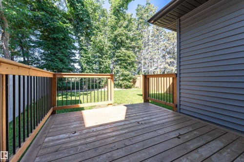 Spacious wooden deck featuring black metal balusters and wood railings - 7322 Chivers Crescent, Edmonton, AB 