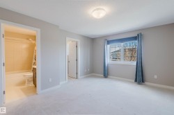 Carpeted room featuring a window with blue drapes, an overhead light fixture, and two doorways - 