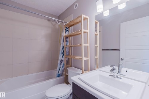 White rectangular bathtub with surrounding wall tile - 2472 Glenridding Boulevard, Edmonton, AB 