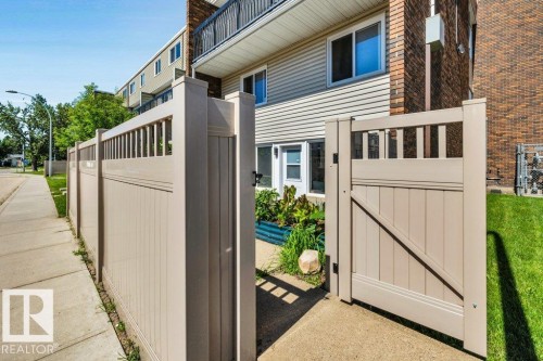 Tan fencing with a matching gate providing access to a private patio area - 102 7805 159 Street, Edmonton, AB 