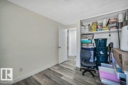 Room featuring wood-finish flooring, white baseboards, and light-toned walls - 