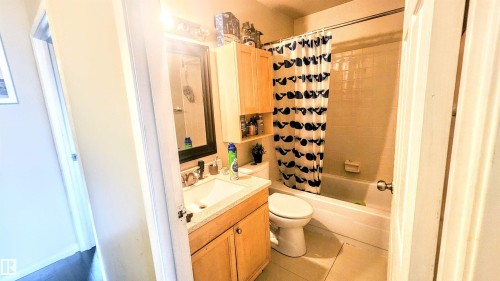 Full bathroom with shower / bathtub combination with curtain, vanity, and light tile patterned flooring - 704 Abbottsfield Road, Edmonton, AB - Indoor Photo Showing Bathroom