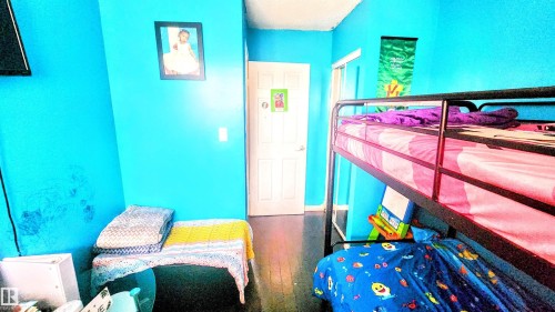 Bedroom with dark wood-style flooring and baseboards - 704 Abbottsfield Road, Edmonton, AB - Indoor Photo Showing Bedroom