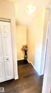 Hallway featuring dark wood-style flooring and a textured ceiling - 