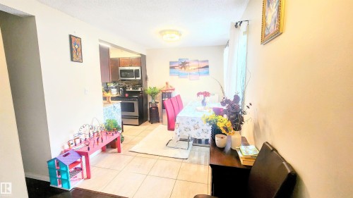 Hall with light tile patterned floors and a textured ceiling - 704 Abbottsfield Road, Edmonton, AB - Indoor