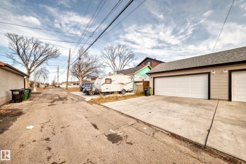 Detached two-car garage featuring panel-style doors and horizontal siding - 2 12042 101 Street, Edmonton, AB 