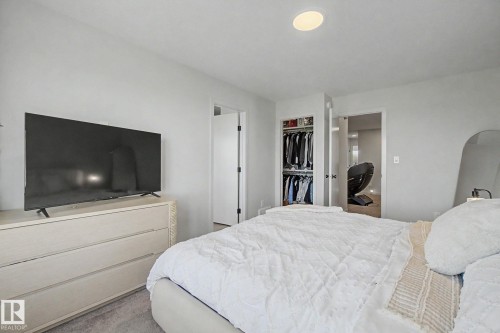 Recessed ceiling lighting illuminates a carpeted room featuring light-colored walls and a closet with a bifold door - 3313 Kulay Way, Edmonton, AB 