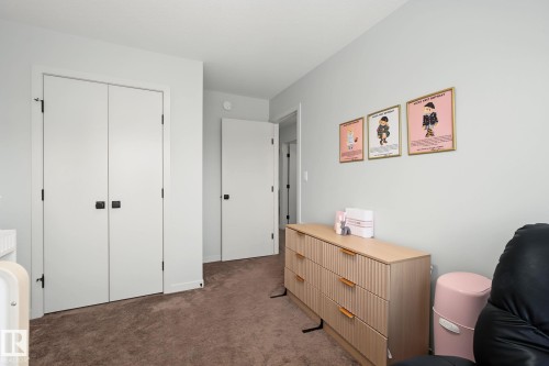 Light gray wall paint, brown carpet flooring, and white interior doors with matte black hardware - 3313 Kulay Way, Edmonton, AB 