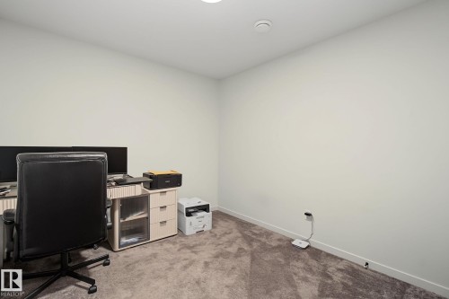 Neutral-toned room featuring a single overhead light fixture and wall outlets - 3313 Kulay Way, Edmonton, AB 