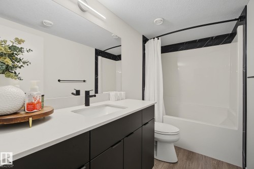 Contemporary bathroom featuring a dark wood-finish vanity with a white countertop, undermount sink, and matte black faucet - 3313 Kulay Way, Edmonton, AB 