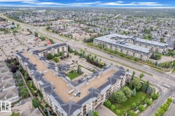 Expansive residential development featuring multiple low-rise buildings with light-colored facades and dark-pitched roofs - 