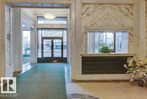 Elegant entry lobby featuring high ceilings and extensive marble wall paneling - 210 10134 100 Street, Edmonton, AB 