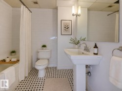 Bathroom featuring a pedestal sink, a full bathtub with white subway tile surround, and a coordinating toilet - 