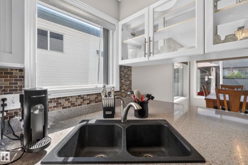 Kitchen sink with a dual basin, a high-arc faucet, and light-colored speckled countertops - 2327 37B Avenue, Edmonton, AB 