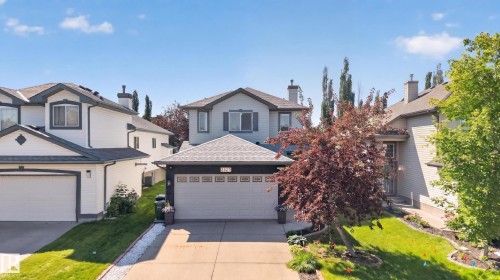Contemporary two-story residence with a two-car garage, featuring a gabled roofline and light-colored siding with dark trim accents - 2327 37B Avenue, Edmonton, AB 