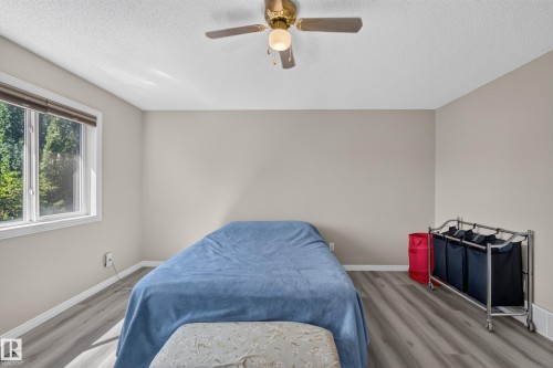 Bright room with wood-finish flooring, a white trim baseboard, and a white ceiling - 2327 37B Avenue, Edmonton, AB 