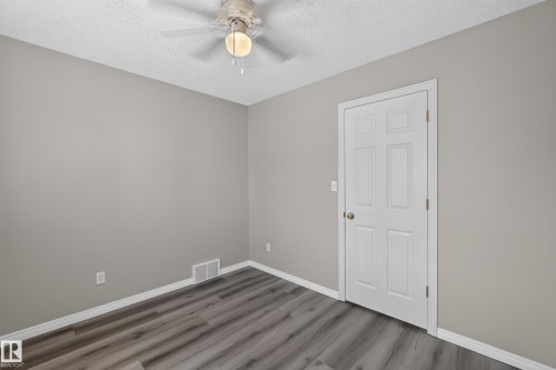 Interior room featuring wood-finish flooring, light grey painted walls, and white baseboards - 2327 37B Avenue, Edmonton, AB 