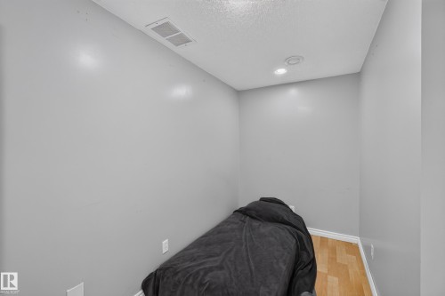 Room featuring light gray walls, wood-finish flooring, white baseboards, and recessed lighting - 2327 37B Avenue, Edmonton, AB 