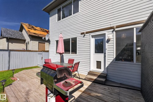 Rear exterior featuring white horizontal siding and a multi-level wood deck - 2327 37B Avenue, Edmonton, AB 
