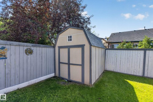Backyard featuring a shed with a gambrel roof and a small window, surrounded by a wood fence - 2327 37B Avenue, Edmonton, AB 