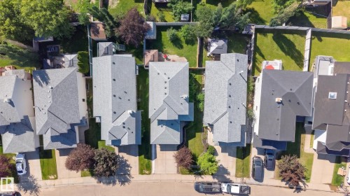 Aerial perspective of a residential street featuring multiple properties with pitched shingle roofs and established landscaping - 2327 37B Avenue, Edmonton, AB 
