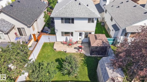 Expansive backyard featuring a manicured lawn, established trees, and a privacy fence - 2327 37B Avenue, Edmonton, AB 