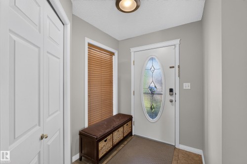 Entryway featuring a decorative oval glass front door, ceramic tile flooring, and a flush mount ceiling light - 2327 37B Avenue, Edmonton, AB 
